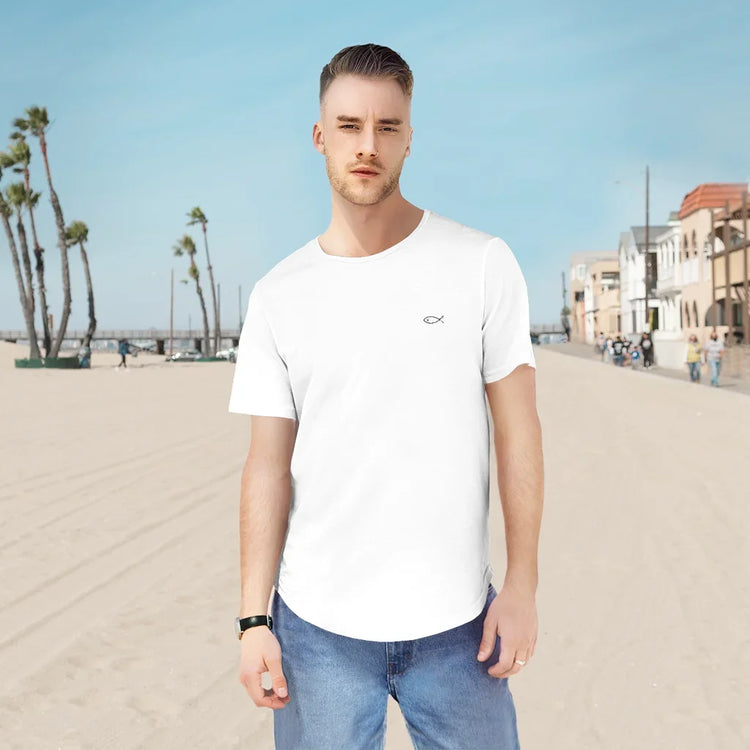 Man wearing white Christian fish symbol t-shirt and blue jeans on a beach boardwalk