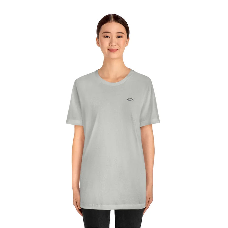 Woman wearing light gray Christian t-shirt with small Ichthys fish symbol on chest